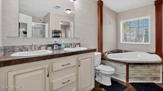 a bathroom with a granite countertop sink a toilet and mirror