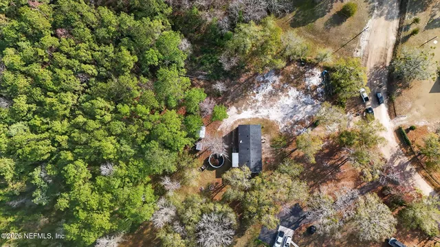 a front view of house with yard and trees in the background