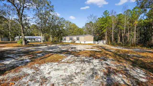 a view of a house with cars parked on the road