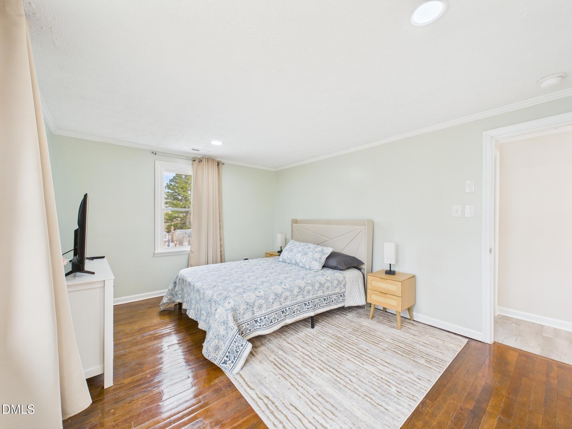 72 Edgemont Avenue Roxboro, NC 27573 - Photo 12 of 45 a bedroom with a bed and wooden floor