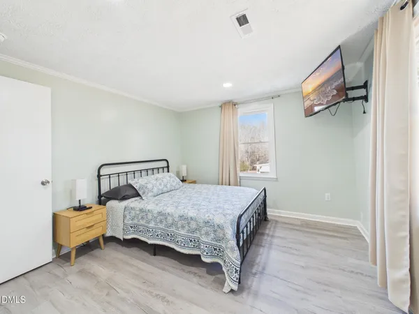 a bedroom with a bed and wooden floor