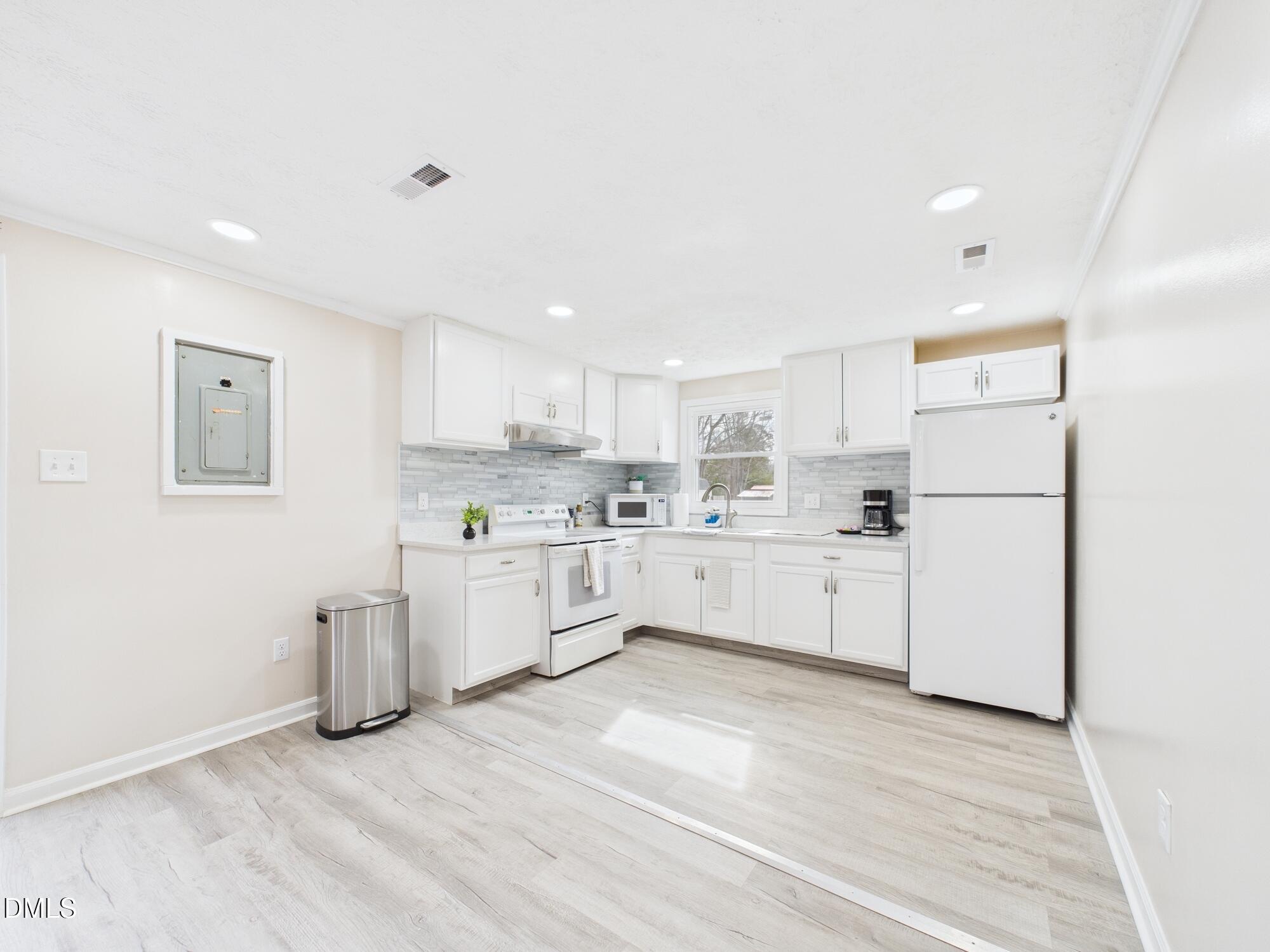 72 Edgemont Avenue Roxboro, NC 27573 - Photo 7 of 45 a kitchen with white cabinets and white appliances