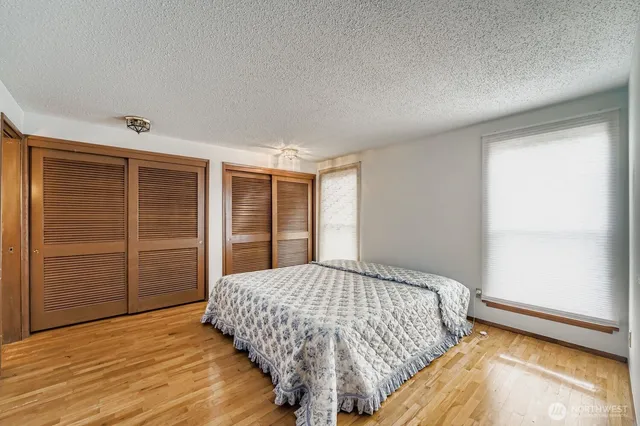 a bedroom with a large bed closet and window