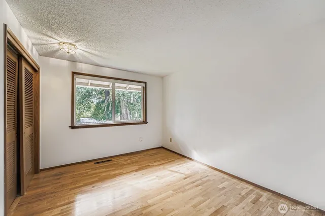 an empty room with wooden floor and window
