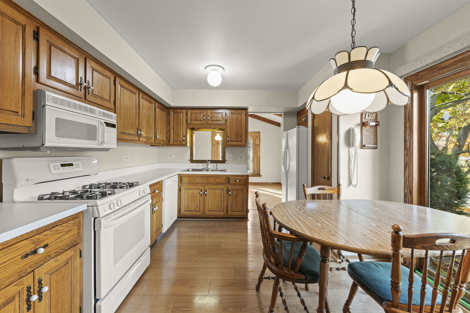 3068 Hickory Road Homewood, IL 60430 - Photo 8 of 44 a kitchen with stainless steel appliances granite countertop a stove a sink dishwasher a dining table and chairs with wooden floor