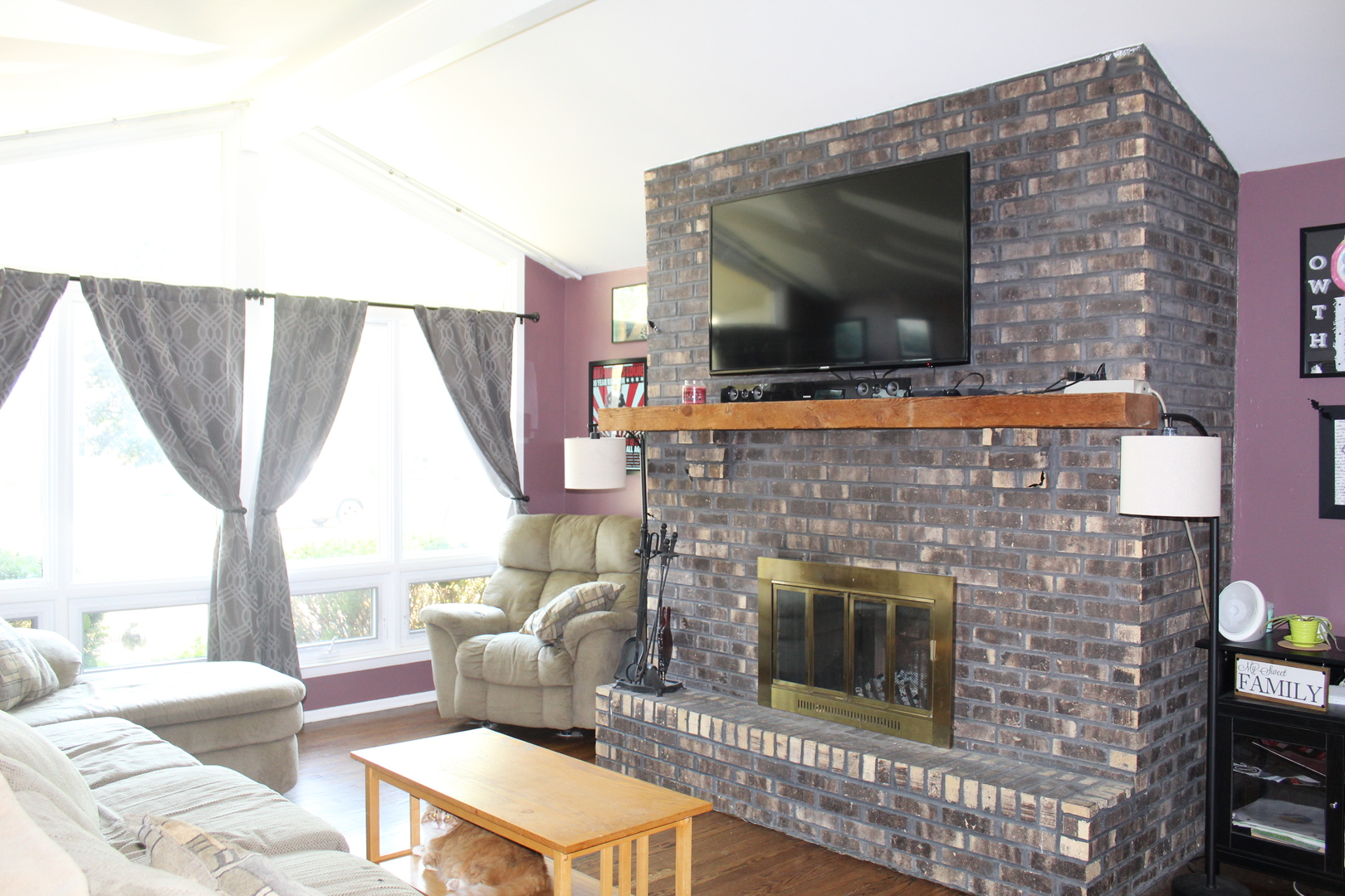 414 Northgate Road Lindenhurst, IL 60046 - Photo 4 of 22 a living room with a fireplace a flat screen tv and a large window