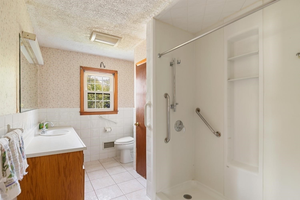 19 Butler Avenue Wakefield, MA 01880 - Photo 18 of 33 a bathroom with a granite countertop sink a toilet and shower