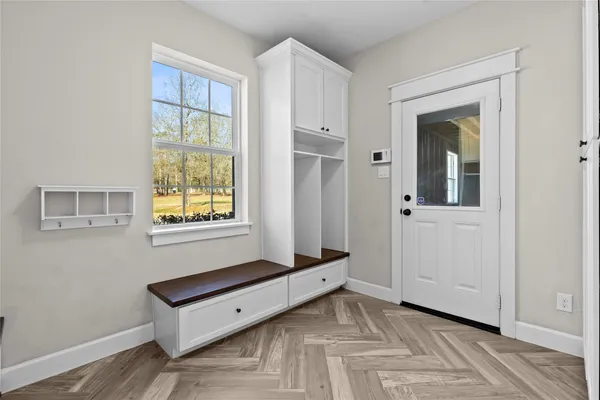 a view of a bedroom with wooden floor and windows