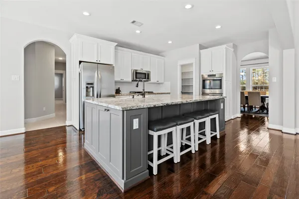 a kitchen with stainless steel appliances granite countertop a refrigerator a stove and a sink