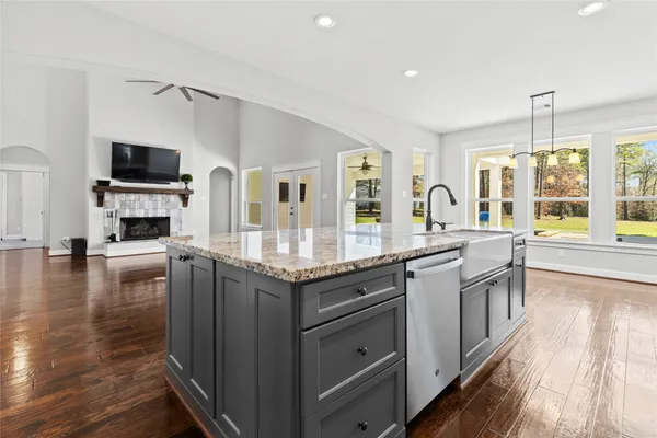 a kitchen with granite countertop a stove and a wooden floors