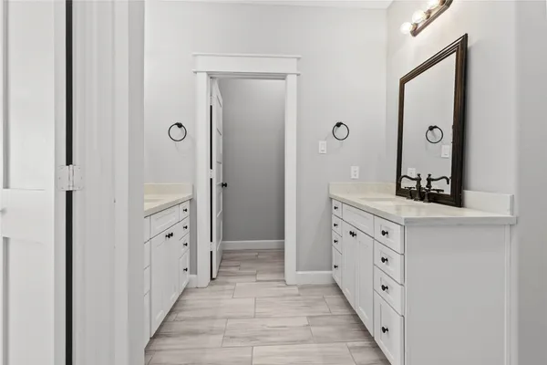 a bathroom with granite countertop a sink a mirror a vanity and a shower