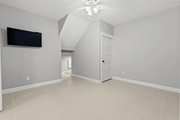 a view of an empty room with a flat screen tv and a window
