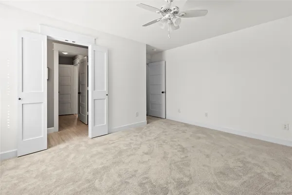 an empty room with chandelier fan