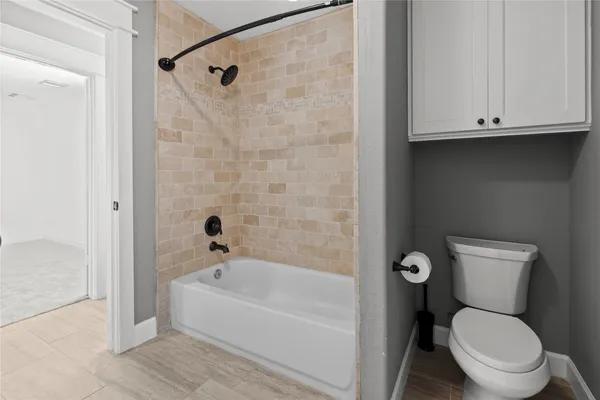 a white toilet sitting next to a bathtub