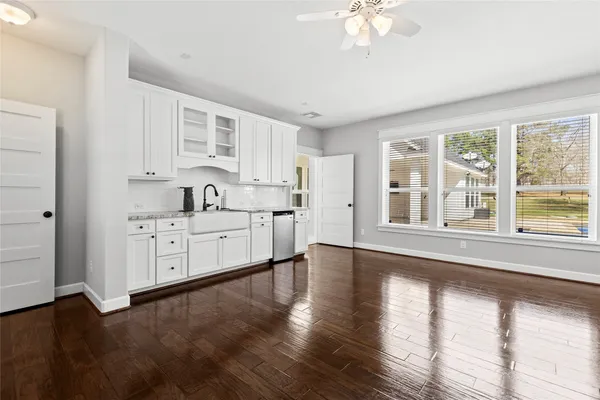 a large white kitchen with window and stainless steel appliances