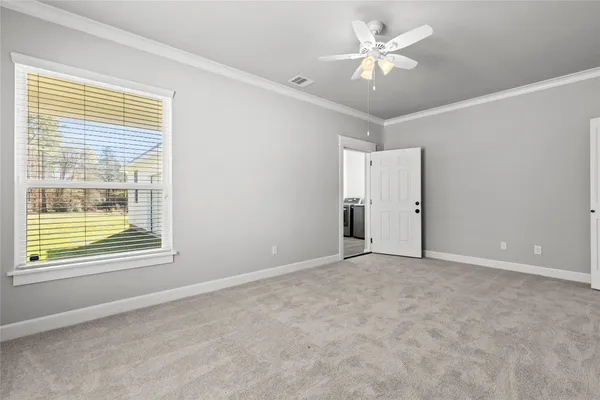 a view of an empty room with a window and a ceiling fan