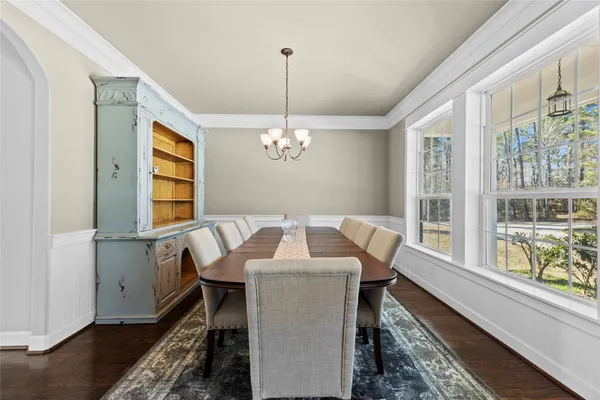 a dining room with furniture a chandelier and wooden floor