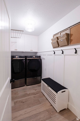 924 Country Lane Farmington, UT 84025 - Photo 63 of 91 Dedicated laundry room featuring wood-finish flooring, white shaker-style cabinetry, and a board and batten accent wall with black coat hooks