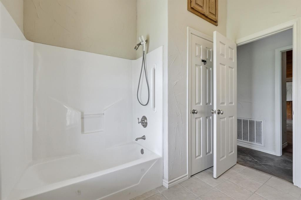 12190 Bell Road Pilot Point, TX 76258 - Photo 30 of 39 White bathtub and shower combination with chrome fixtures