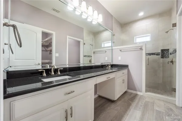 a large white kitchen with a sink and a large mirror