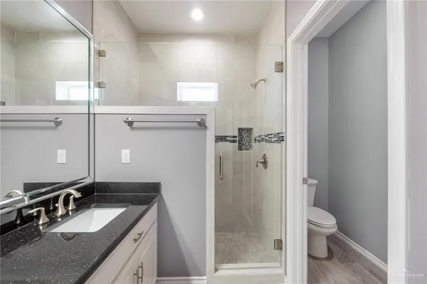 a bathroom with a granite countertop sink toilet and shower