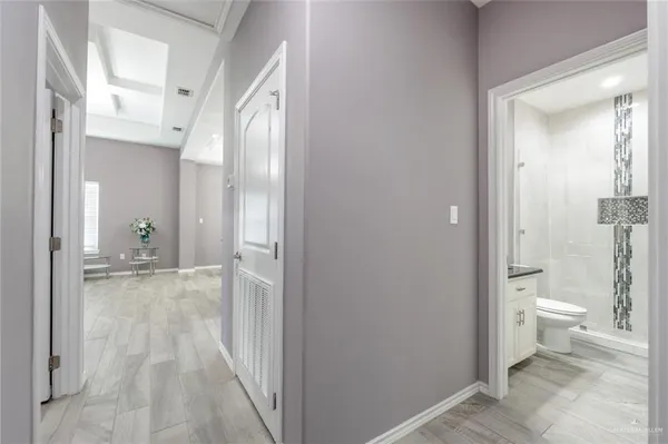 a bathroom with a granite countertop toilet a sink and a view of bathroom