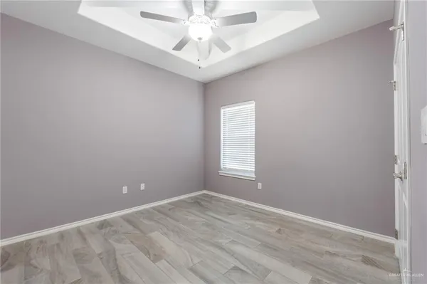 an empty room with a window and ceiling fan