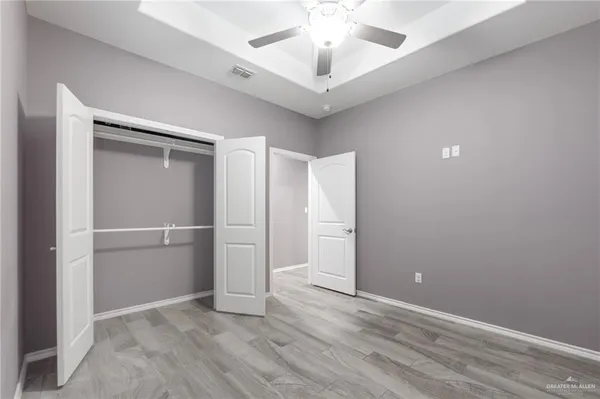 an empty room with closet and windows