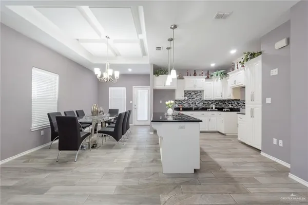 a kitchen with a dining table chairs and white cabinets