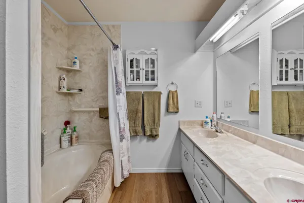 a bathroom with a granite countertop tub sink a mirror and vanity
