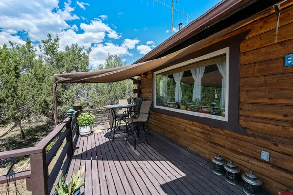 a balcony with wooden floor and outdoor seating