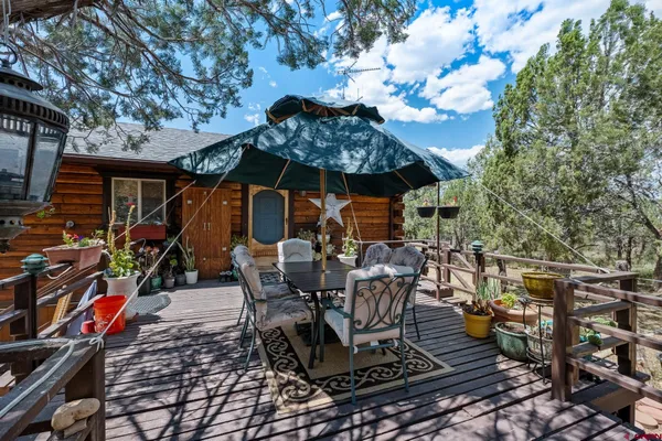 a view of a patio with table and chairs under an umbrella