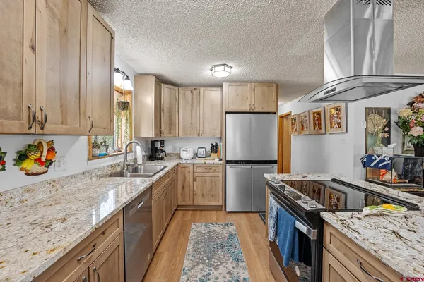 a kitchen with stainless steel appliances granite countertop a sink stove and refrigerator