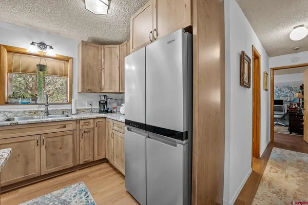 a kitchen with stainless steel appliances granite countertop a refrigerator and a sink