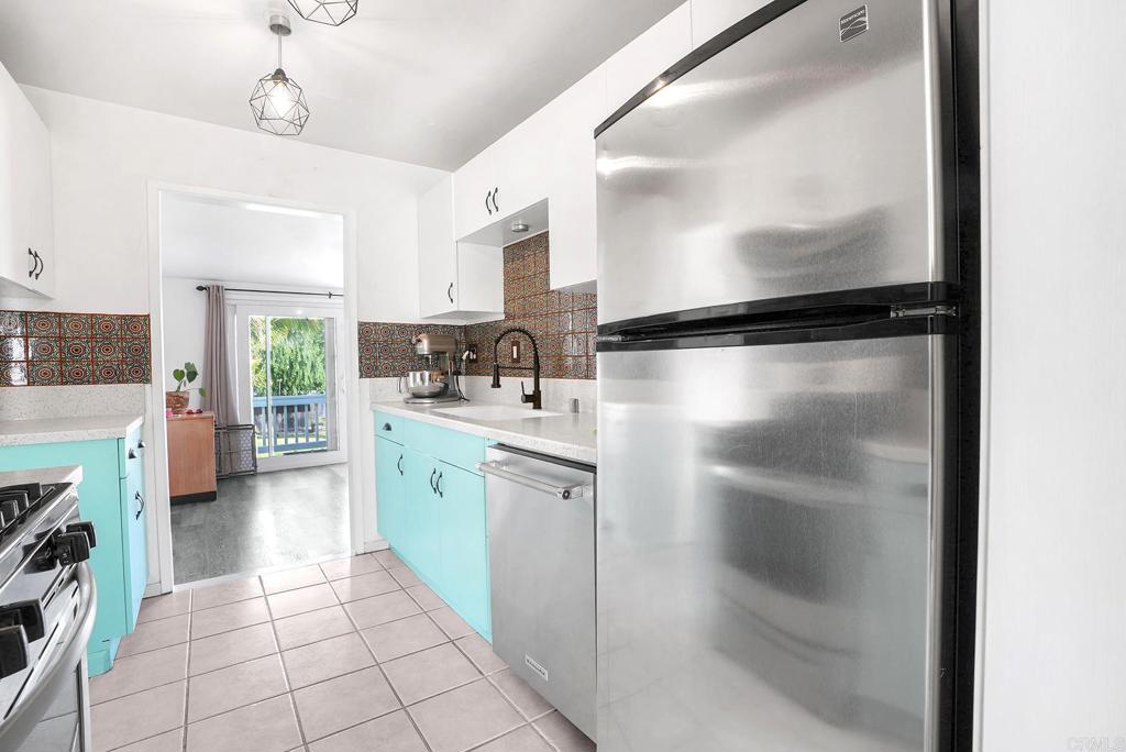 511 El Monte Road El Cajon, CA 92020 - Photo 19 of 30 a kitchen with a refrigerator a sink and a stove top oven