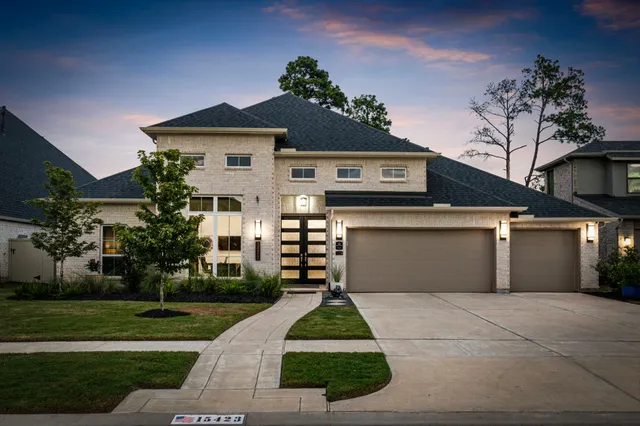 a front view of a house with a yard and potted plants