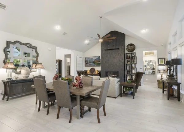 a kitchen with stainless steel appliances kitchen island granite countertop a table chairs and a refrigerator