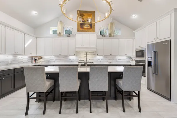a kitchen with kitchen island granite countertop a sink window and white cabinets
