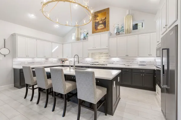 a kitchen with cabinets a sink stainless steel appliances and dining table