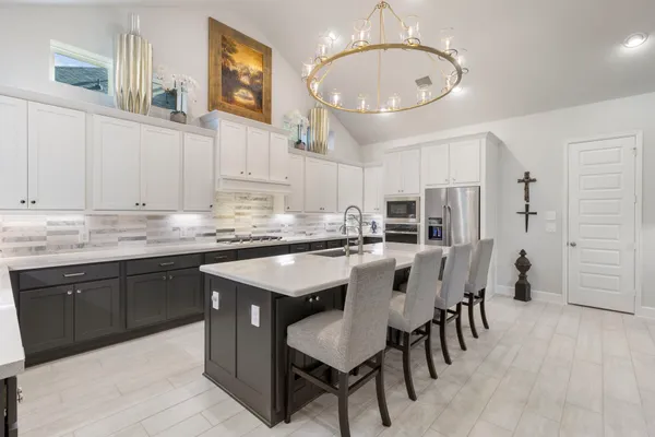 a kitchen with stainless steel appliances granite countertop a sink a stove and a refrigerator