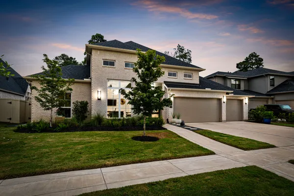 a front view of a house with a yard and trees