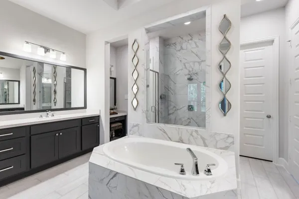 a en suite spacious bathroom with a granite countertop sink and a mirror