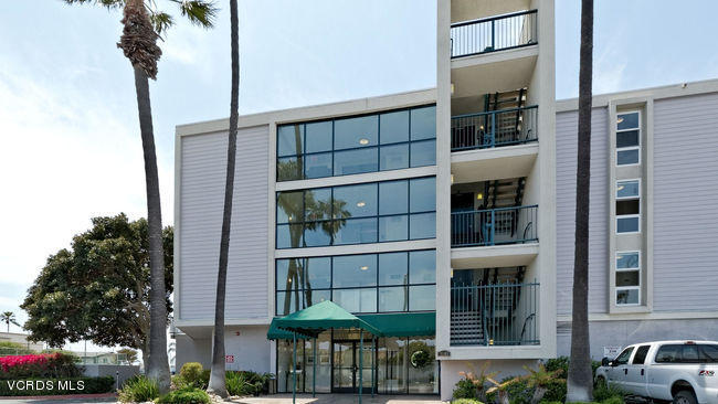 3101 Peninsula Road, Unit 105 Oxnard, CA 93035 - Photo 12 of 36 a front view of a building with a yard and balcony