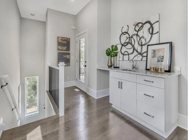 a kitchen with white cabinets and wooden floor