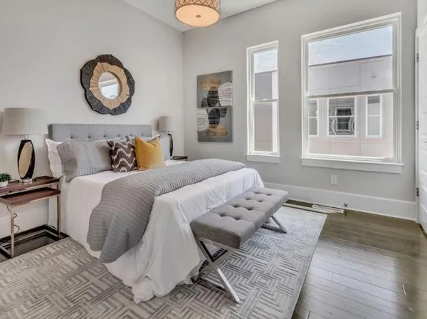 a bedroom with a bed and wooden floor