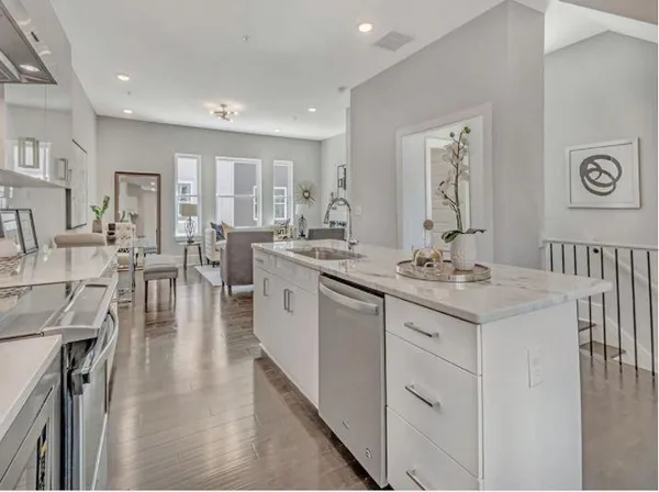 a large white kitchen with lots of counter space a sink and appliances