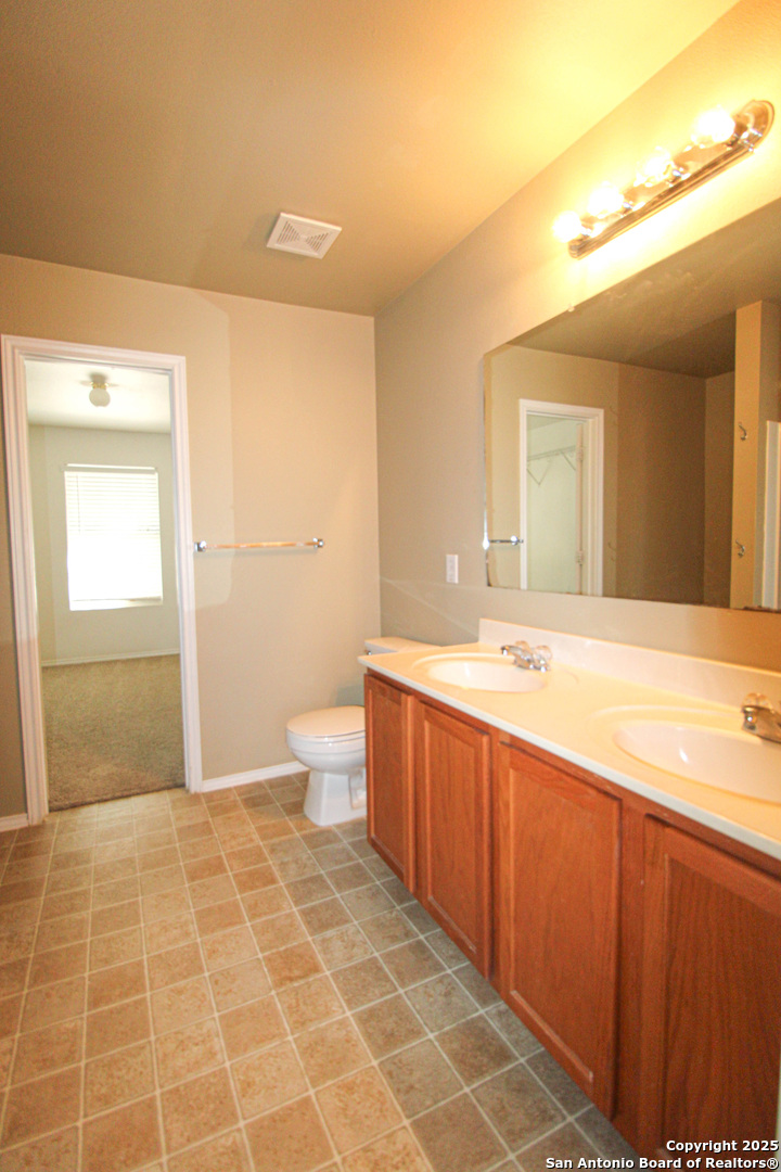 20823 Blue Trinity San Antonio, TX 78259 - Photo 20 of 46 a spacious bathroom with a granite countertop sink a toilet and a mirror