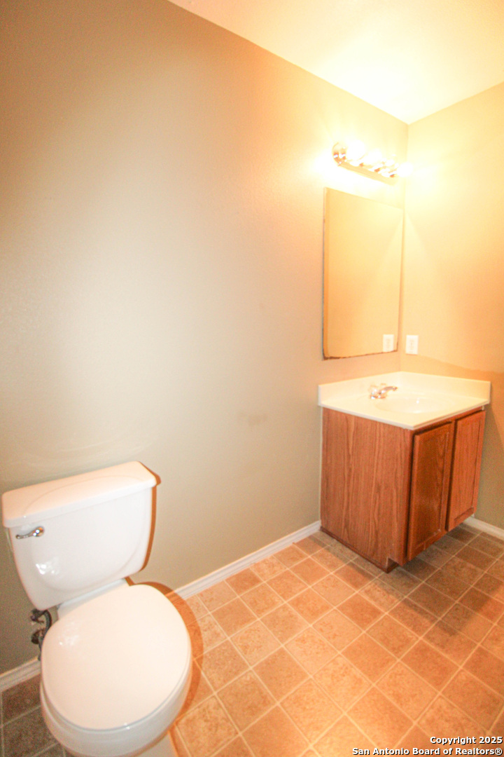 20823 Blue Trinity San Antonio, TX 78259 - Photo 45 of 46 a bathroom with a toilet a sink and mirror