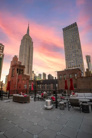 a roof deck with couch and potted plants