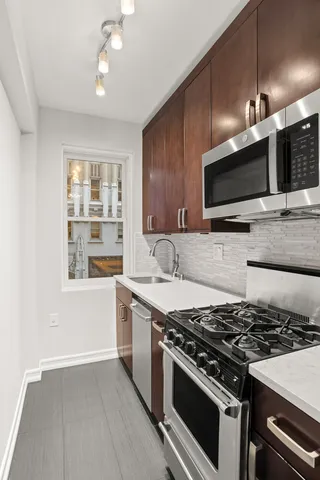 a kitchen with stainless steel appliances a refrigerator and a stove top oven